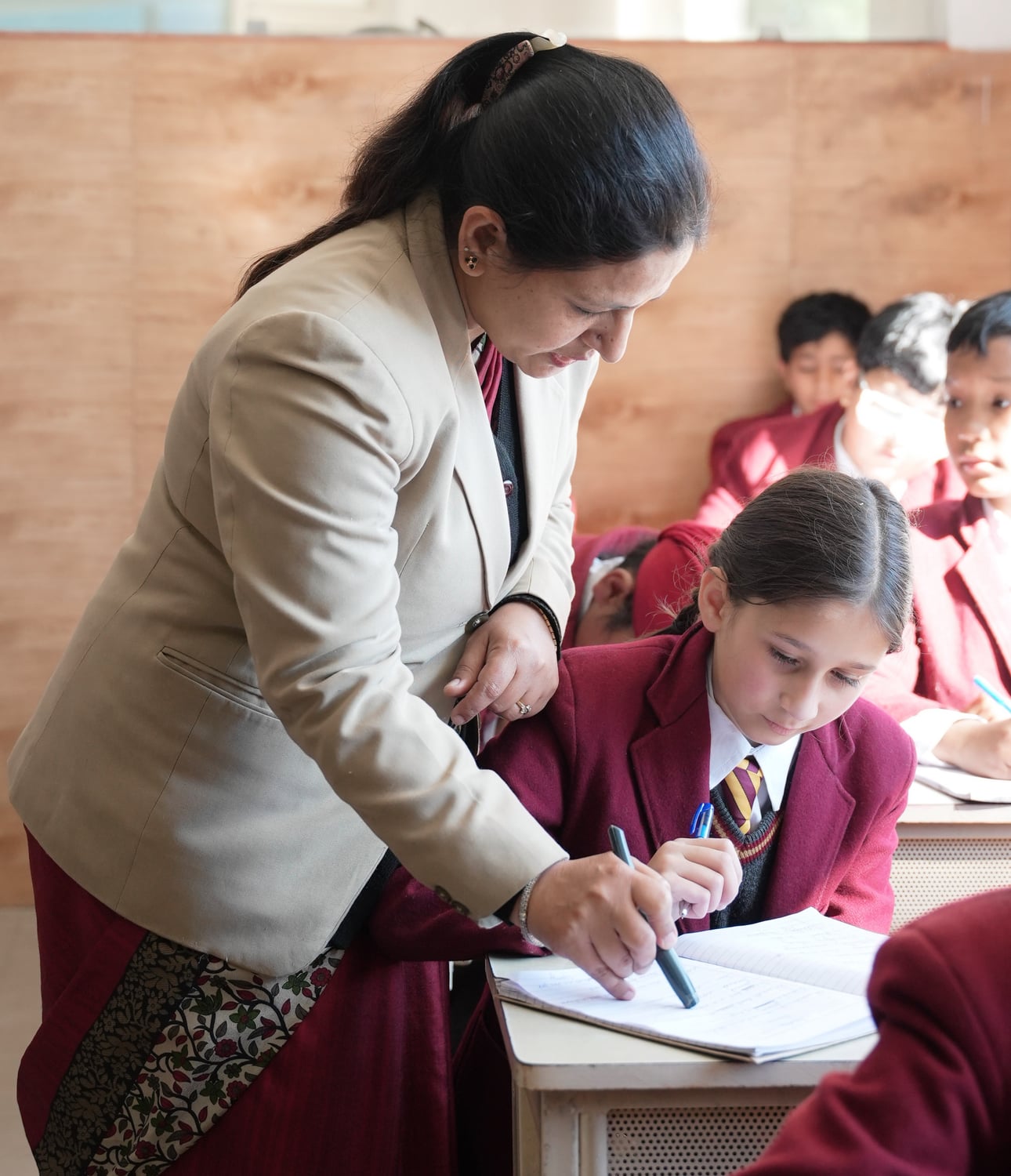 A teacher helping a student with her work