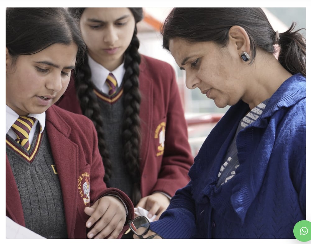 A teacher going over work with two students