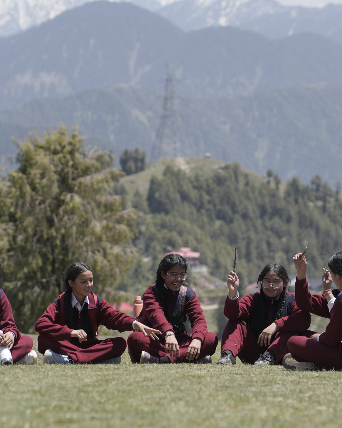Students resting on the grass below the peaks