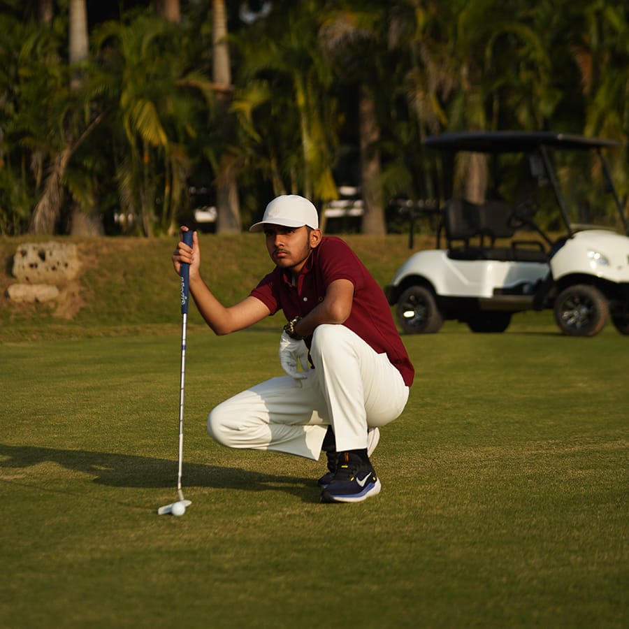 A student lining up a putt on the golf green